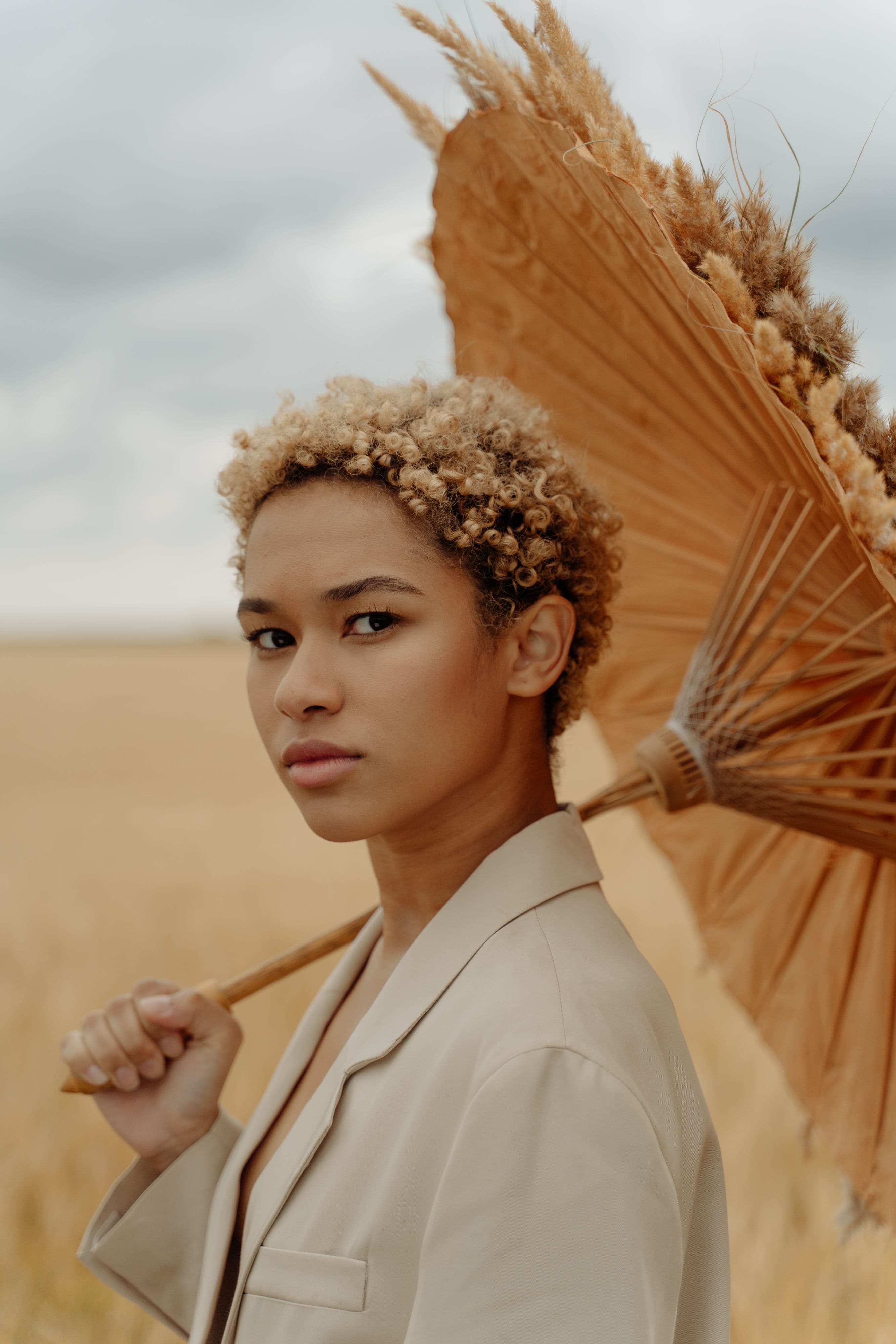 Two models in beige suits standing in a wheat field