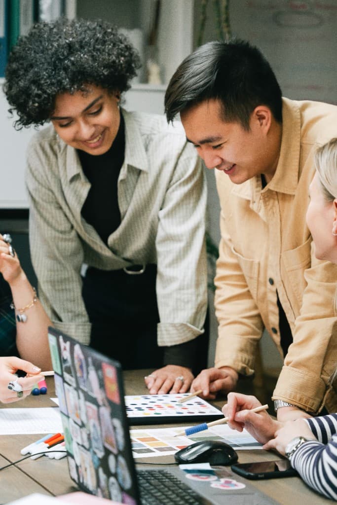 A small creative team collaborating around a desk