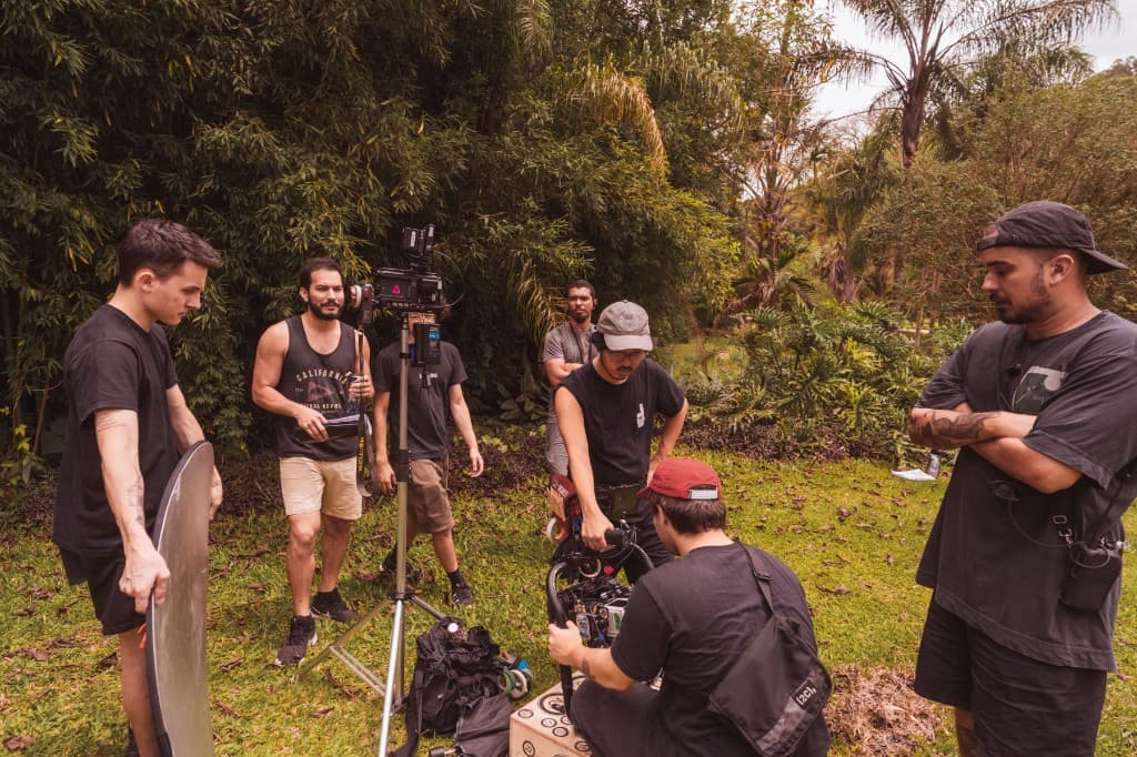 A small production crew setting up a camera outdoors